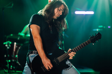 Obraz premium Guitarist performing live on stage with band in background
