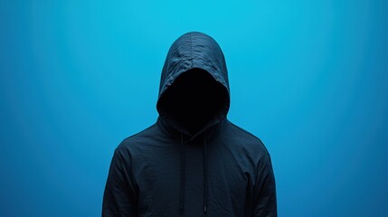 Mysterious Figure in Hoodie Against a Vibrant Blue Background