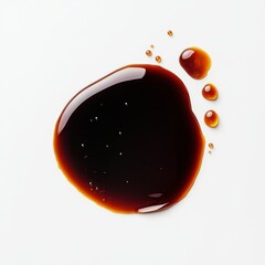 A glossy, dark liquid drop resembling soy sauce or a similar condiment.