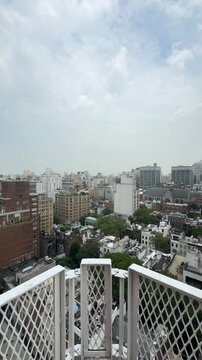 A stunning vertical orientation push-in shot from a rooftop overlooking E 63rd Street in New York City, showcasing the dynamic Manhattan skyline and vibrant cityscape from above.