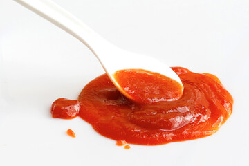 white spoon on chili sauce with white background