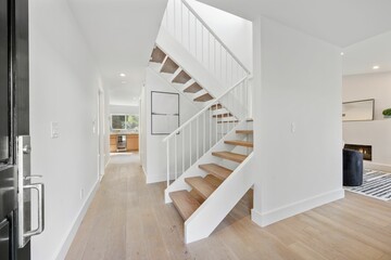 Obraz premium Modern hallway with wooden floor and staircase.