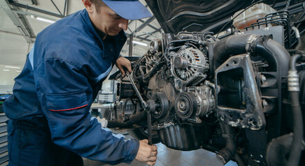 Fototapeta premium Auto mechanic repairs an engine. Replacing the timing chain