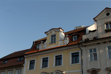 Obraz premium A stunning view of a historic building, showcasing its ornate roof and elaborate facade details, set against the backdrop of a vibrant European city, captivating visitors and tourists alike