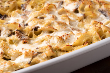 Tagliatelle gratinate al forno con panna e funghi, pasta italiana 