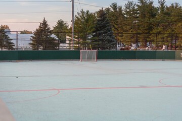 view of an unoccupied roller hockey rink in a city park at dawn