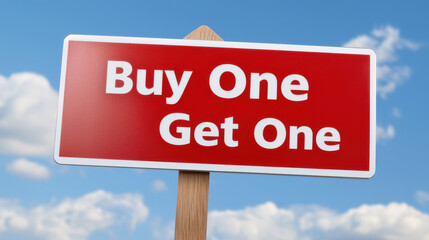 Obraz premium Buy one get one sign against blue sky with clouds, promoting sale