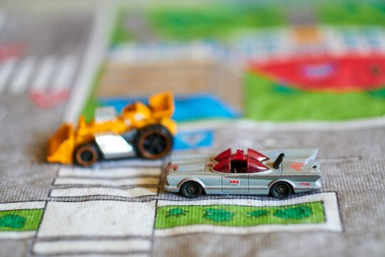 Selective focus of the Mattel Hot Wheels toy model Batmobile car on a play road mat