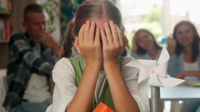 Sad upset crying bullied stressed girl schoolgirl female child kid teen teenager student pupil at school cry frustrated with bullying mocking aggressive pupils classmates studying education problem