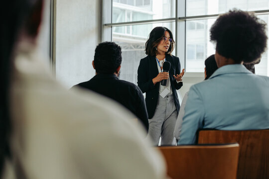 Businesswoman presenting in modern office to coworkers during a meeting