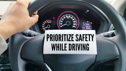 Obraz premium car steering wheel and paper with the words Prioritize safety while driving. the concept of prioritizing safety while driving