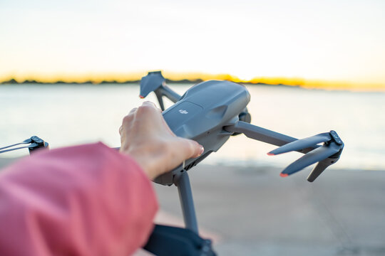 Novalja, Croatia - November 16, 2024: Woman holds a new drone DJI air 3s against a sea backdrop 