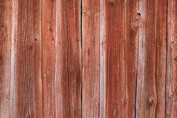 Fototapeta premium Alte verwitterte Bretter ab einer Wand, texturiertes Holz, rote Farbe, Hintergrund mit vertikalen Linien