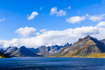 Autumn landscape in Lofoten Islands, Northern Norway, featuring colorful foliage, and a peaceful fjord.