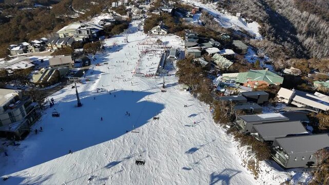 Aerial view of Mount Buller ski resort in winter, showing snow-covered mountain scenery and numerous skiers on the slopes