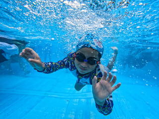 水中ゴーグルをかけて泳ぐ少年