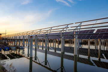 At sunset, the frame of the solar panel and the construction site