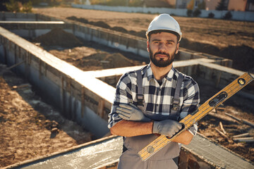 Tool for measuring leveling of surface. Worker is on the construction site at daytime