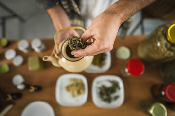 close up of man herbalist make a tea from natural herbs at workshop