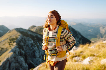 Woman on a hiking trip in the mountains having a break. Beautiful mountains landscape. Adventure active.