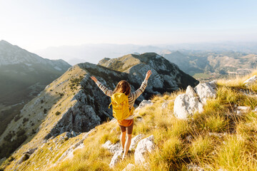 Woman on a hiking trip in the mountains having a break. Beautiful mountains landscape. Adventure active.