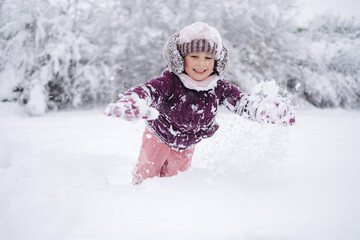 Little girl wearing a cozy winter outfit, happily exploring deep snow. The pure white snow surrounds her, creating a dreamy winter scene full of childhood wonder