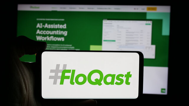 Stuttgart, Germany - 10-31-2024: Person holding cellphone with logo of US accounting software company FloQast Inc. on screen in front of business webpage. Focus on phone display.