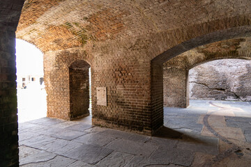 Historical brick fort with arched corridors, antique cannons, and weathered structures, showcasing...