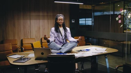 A Meditative Businesswoman in a modern office blends ambition with balance, staying calm and focused in a creative, productivitydriven workspace that inspires innovation and wellness