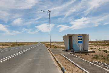 blue bus stop and a bus stop sign on a pillar in the steppe of Kazakhstan, Mangystau Region