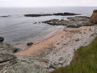 Rocky Beach with Peach Sand, Small Island and Calm Sea
