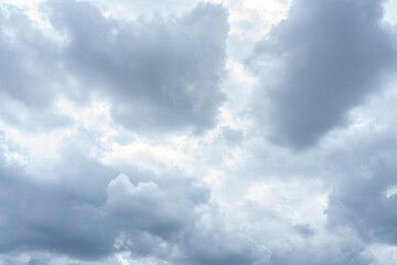 Fluffy white clouds drift across a vibrant blue sky