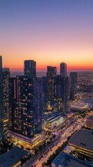 Naklejka premium aerial shot of a bustling cityscape at dusk, with skyscrapers illuminated by pastel-toned sunset reflection 