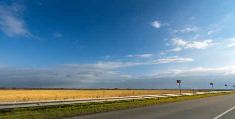 A long, empty road with a blue sky above
