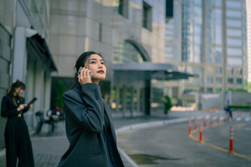 Fototapeta premium A young professional businesswoman working in a city with many tall buildings.