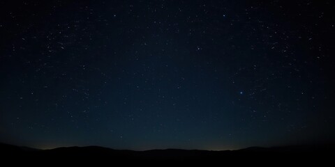 Fototapeta premium Dense cluster of bright stars against a dark canvas with subtle starlight reflections on the surrounding landscape, universe, stars