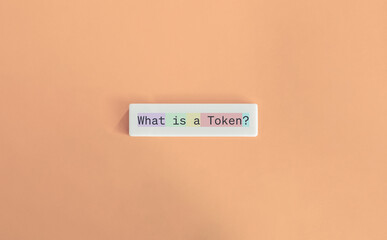 What is a Token? Generative AI Concept Image. Text on Block Letter Tile on Dusty Pink Background....