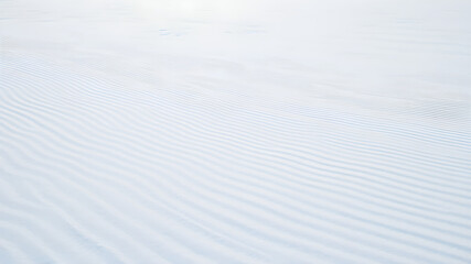 Obraz premium 8K Snow Background On a vast open space covered with pure white snow, the snow is patterned with fine stripes from the wind.
