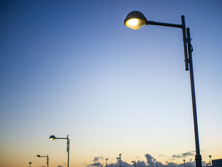 Illuminated Street Lamp at Sunset with Blue and Yellow Sky