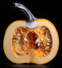 Pumpkin cut in half against black background