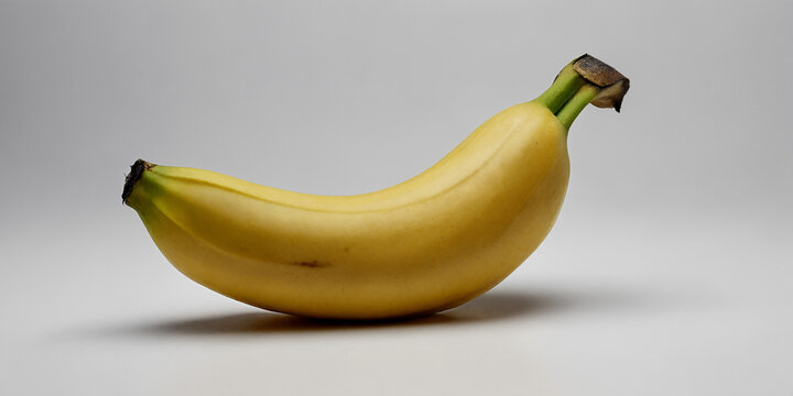 Perfekt gelbe Banane mit gl&auml;nzender Schale und makellosem Stil in Studioaufnahme