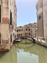 small canal through a narrow street in Venice