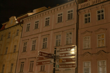 The stunning nighttime view of historic buildings adorned with street signs beautifully showcases...