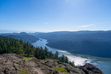 Landscape at Saanich inlet with rocky hill and pinetrees in foreground