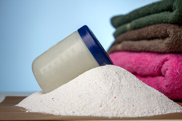 Washing powder and clean towels on a blue background