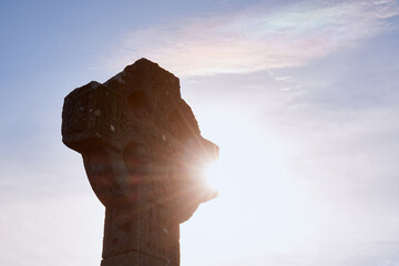 11th-century Celtic Cross at Drumcliffe Church with sunlight shining through, Ireland