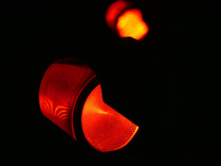 Red traffic light close up in the dark on a black background