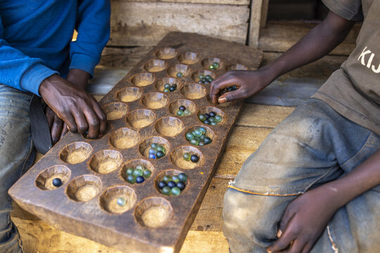 Teenagers playing awele in Murhesa, South Kivu, DRC
