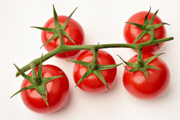 Photograph of red cherry tomatoes on the vine on white background. Top view. 