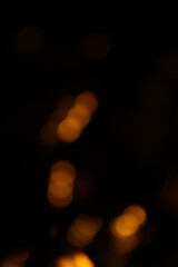 Fototapeta premium Red and fire orange bokeh on a black background, bokeh abstract background, modern abstract backdrop. Orange Christmas background, Xmas backdrop. Halloween scary concept, Halloween bokeh background 